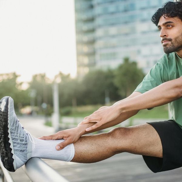 Person stretching outdoors in a park during sunrise.